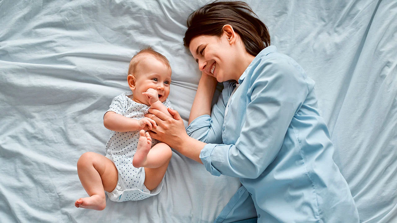 Mamá y su bebé felices en la cama