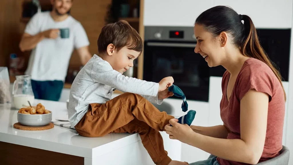 Mama abrigando con medias los pies de su pequeño hijo