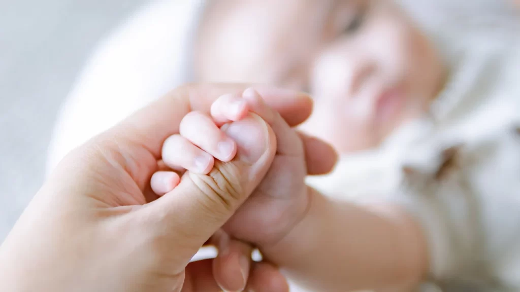 Mamá tomando a bebe de la mano